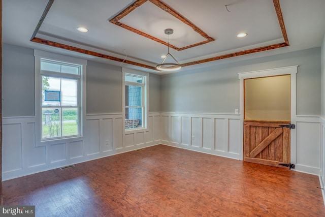 unfurnished room featuring dark hardwood / wood-style flooring and a raised ceiling