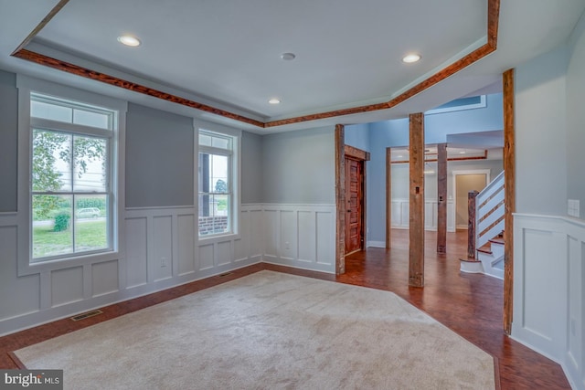 empty room with a tray ceiling and dark hardwood / wood-style flooring