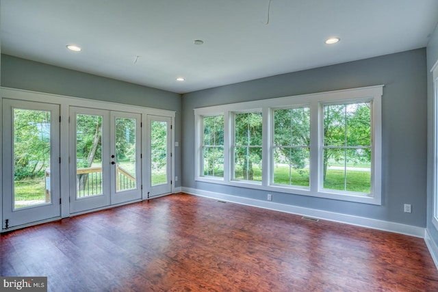 spare room with dark hardwood / wood-style flooring, a wealth of natural light, and french doors