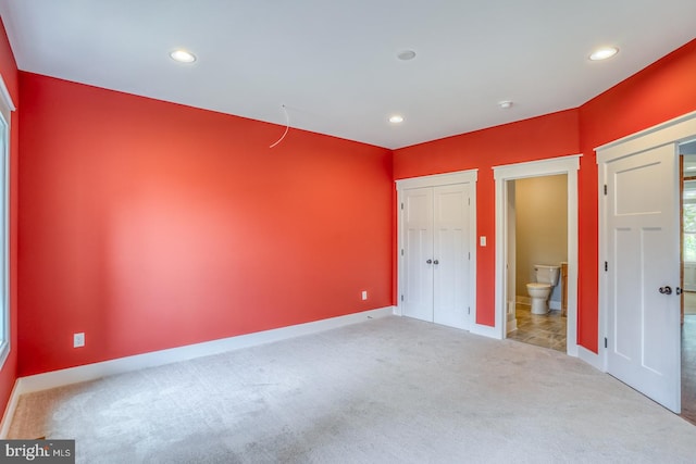 unfurnished bedroom with light carpet and ensuite bathroom