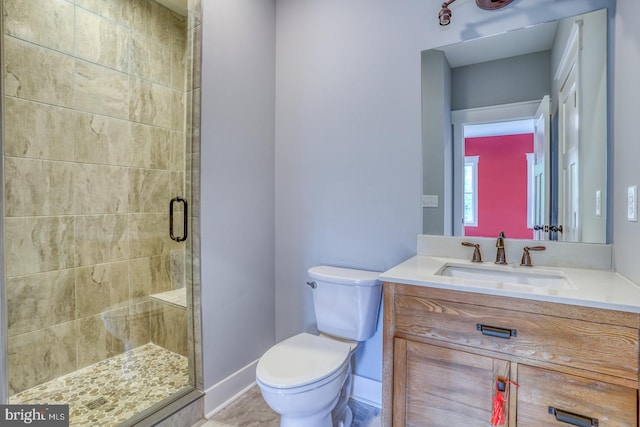 bathroom featuring vanity, toilet, and walk in shower