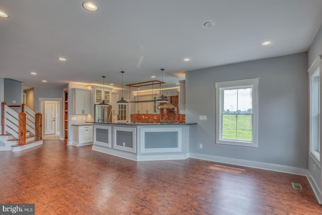 kitchen featuring kitchen peninsula, backsplash, and hardwood / wood-style flooring