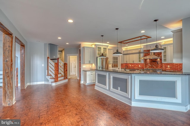 kitchen featuring dark hardwood / wood-style flooring, tasteful backsplash, and decorative light fixtures