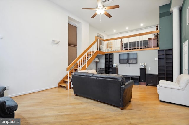 living room with ceiling fan, light hardwood / wood-style flooring, and ornate columns