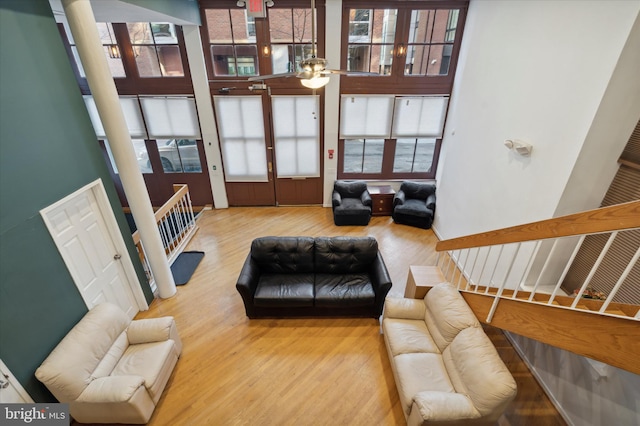 living room with a high ceiling, light hardwood / wood-style floors, and french doors