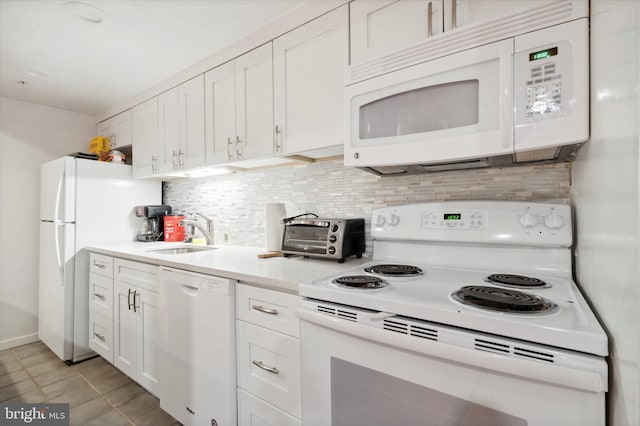 kitchen with white appliances, sink, light tile floors, white cabinets, and backsplash