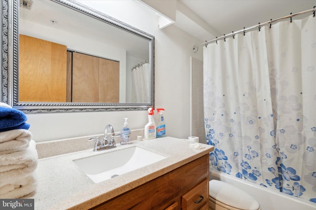 full bathroom featuring toilet, shower / tub combo with curtain, and vanity with extensive cabinet space