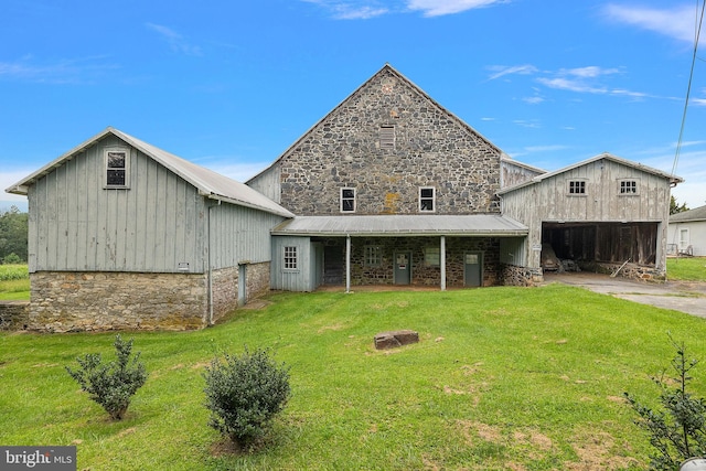 rear view of house featuring a yard and a garage