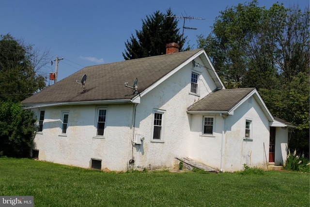 rear view of property with a lawn