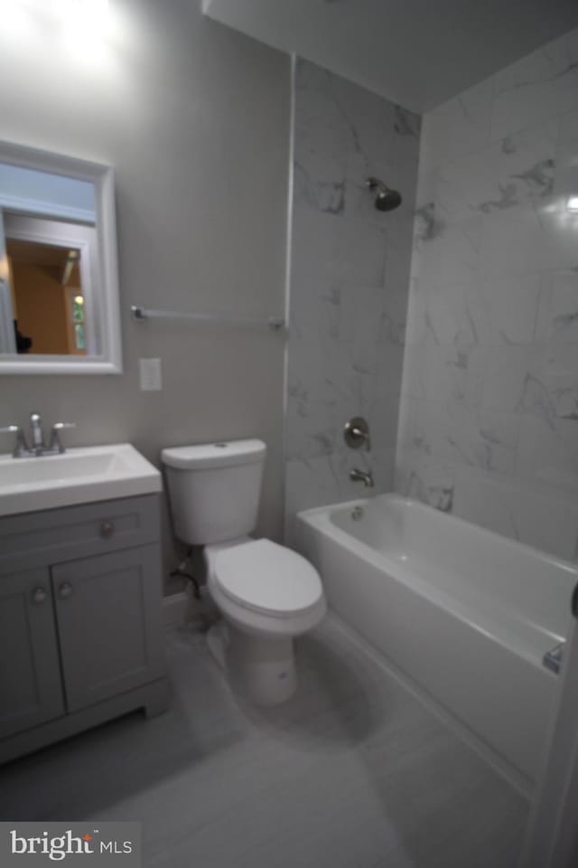 full bathroom featuring tile flooring, vanity, toilet, and tiled shower / bath