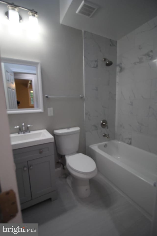 full bathroom with toilet, tile floors, tiled shower / bath combo, and vanity