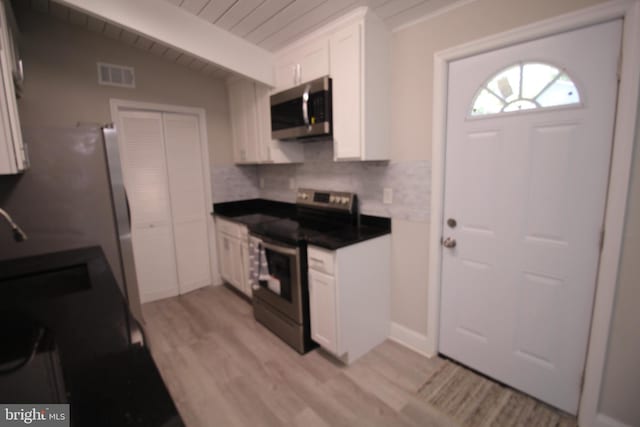 kitchen with white cabinets, appliances with stainless steel finishes, and light wood-type flooring