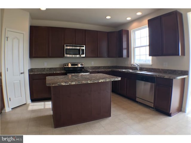 kitchen with a kitchen island, appliances with stainless steel finishes, sink, and dark brown cabinetry