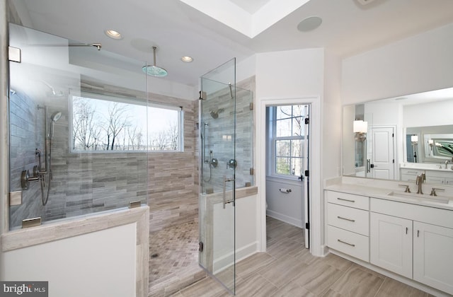 bathroom featuring tile patterned flooring, a shower with shower door, and vanity