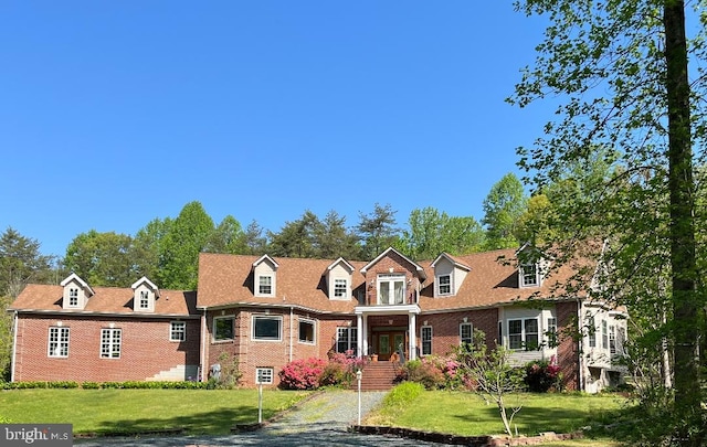 cape cod home featuring a front yard