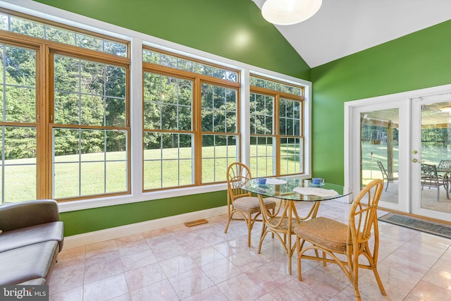 sunroom / solarium with a healthy amount of sunlight, lofted ceiling, and french doors