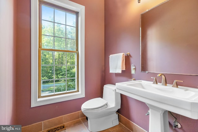 bathroom featuring toilet, tile patterned floors, and sink