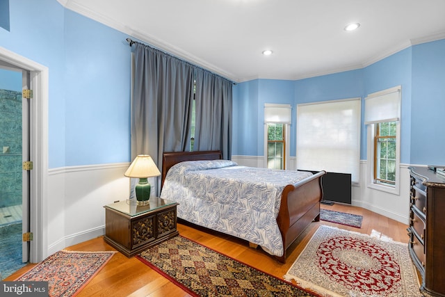 bedroom with crown molding and light hardwood / wood-style floors