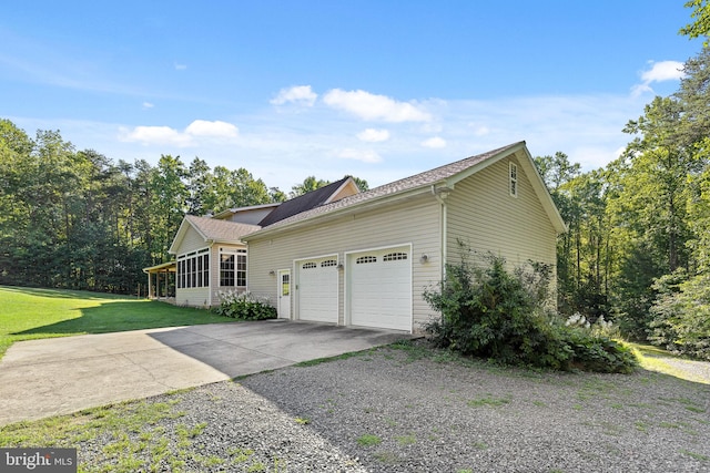 view of side of home featuring a garage and a yard