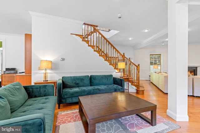 living room with light hardwood / wood-style floors and crown molding