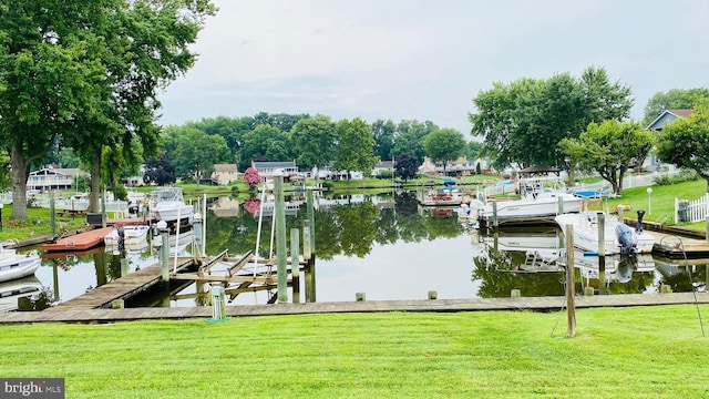 view of dock featuring a water view and a yard