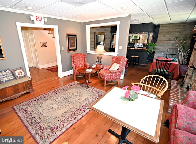 living room with dark hardwood / wood-style flooring and a paneled ceiling