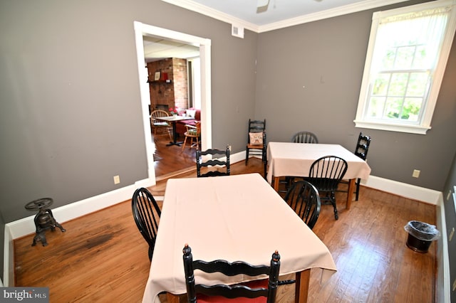 office space featuring brick wall, ornamental molding, and wood-type flooring