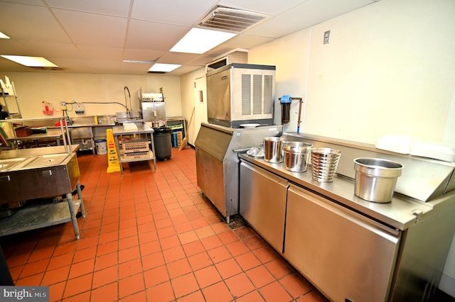 kitchen featuring tile flooring and a drop ceiling