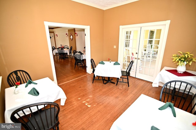 dining area featuring french doors, ornamental molding, and hardwood / wood-style floors