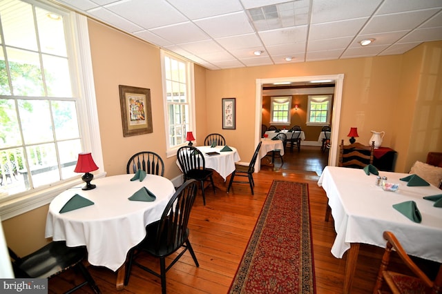 dining space featuring dark hardwood / wood-style flooring and a paneled ceiling