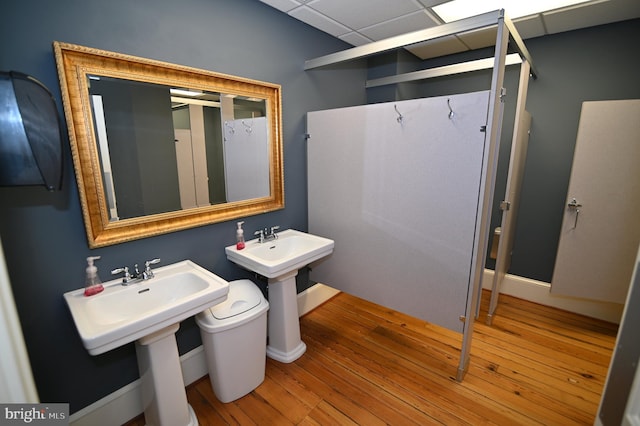 bathroom featuring hardwood / wood-style floors, toilet, a drop ceiling, and sink