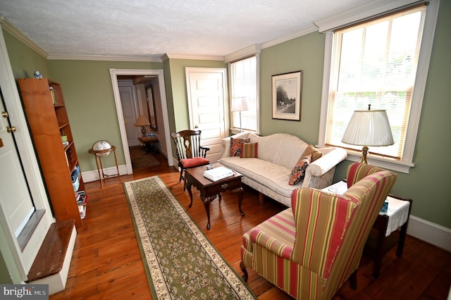 living room with dark hardwood / wood-style floors, ornamental molding, and a textured ceiling