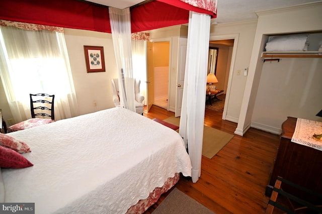 bedroom featuring a closet, ornamental molding, and wood-type flooring