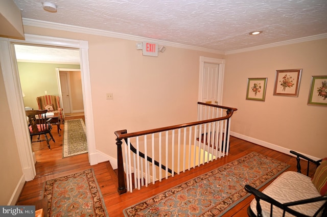 interior space with a textured ceiling, dark hardwood / wood-style flooring, and ornamental molding