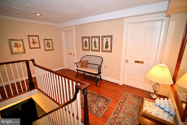 interior space featuring ornamental molding, dark wood-type flooring, and a textured ceiling