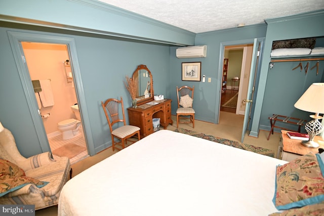 bedroom with a closet, a textured ceiling, connected bathroom, ornamental molding, and a wall unit AC