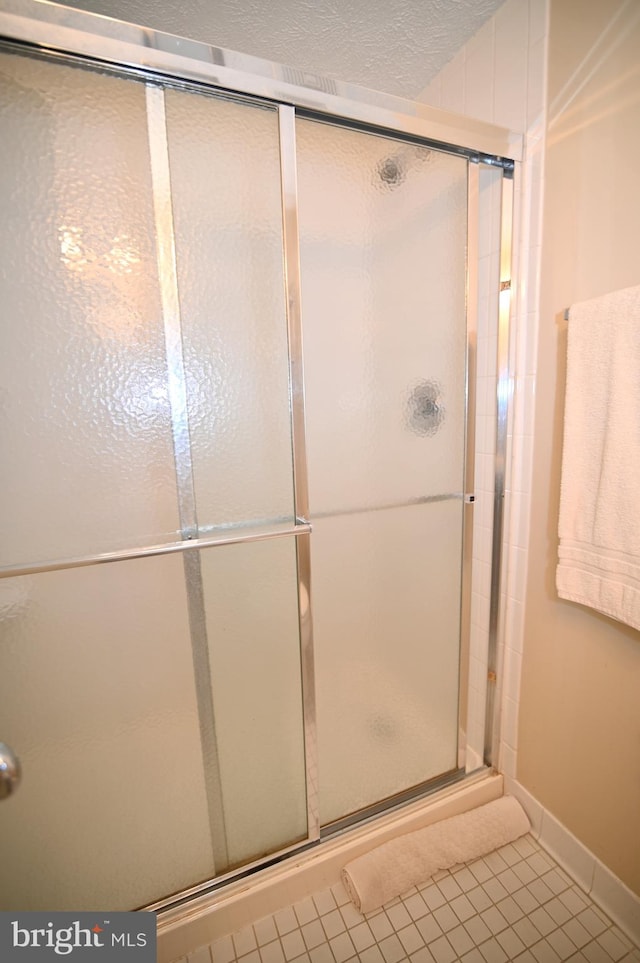 bathroom with an enclosed shower and tile floors