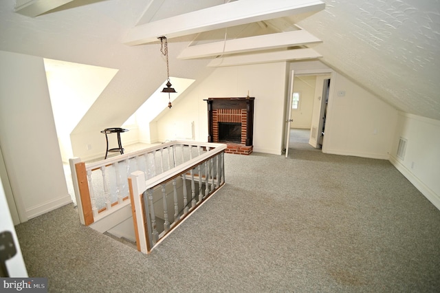 additional living space with a textured ceiling, carpet floors, and lofted ceiling with beams