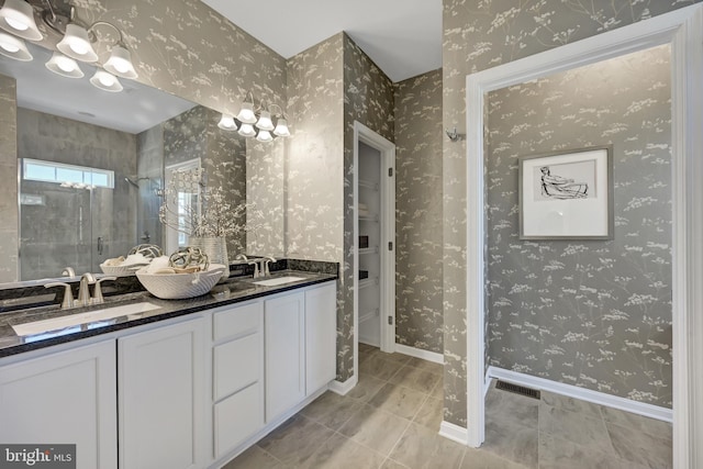 bathroom with toilet, oversized vanity, tiled shower, dual sinks, and tile flooring