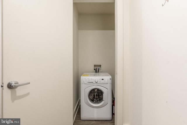 washroom with dark hardwood / wood-style flooring and washer / dryer