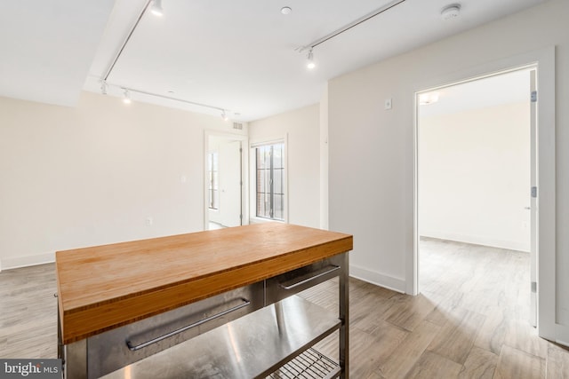 unfurnished dining area featuring hardwood / wood-style flooring and rail lighting