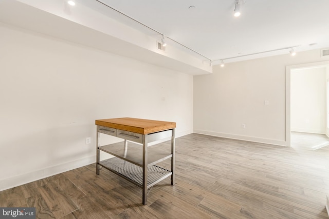 unfurnished room featuring rail lighting and light hardwood / wood-style floors