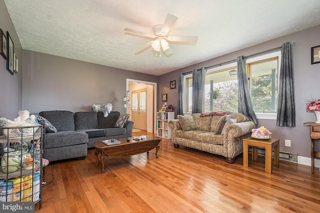 living room with a textured ceiling, light hardwood / wood-style floors, ceiling fan, and baseboard heating