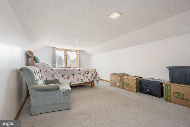 bedroom with lofted ceiling, light carpet, and a textured ceiling