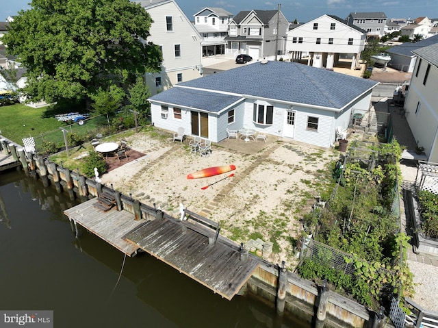 back of property with a patio and a water view