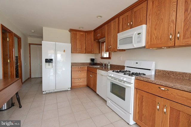 kitchen with white appliances, light tile flooring, and sink