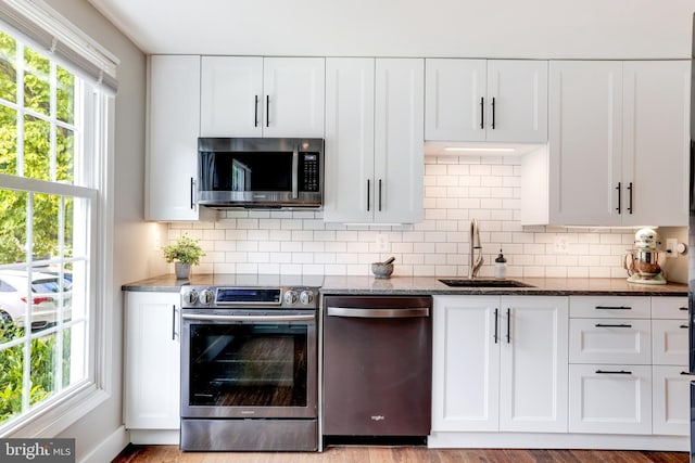 10905 Harpers Square Ct, Reston, VA 20191 - kitchen featuring dark stone counters, appliances with stainless steel finishes, decorative backsplash, and a sink