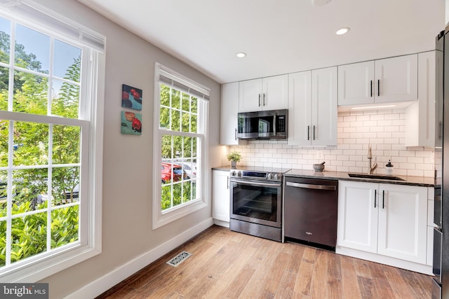 10905 Harpers Square Ct, Reston, VA 20191 - kitchen with decorative backsplash, a sink, appliances with stainless steel finishes, visible vents, and baseboards