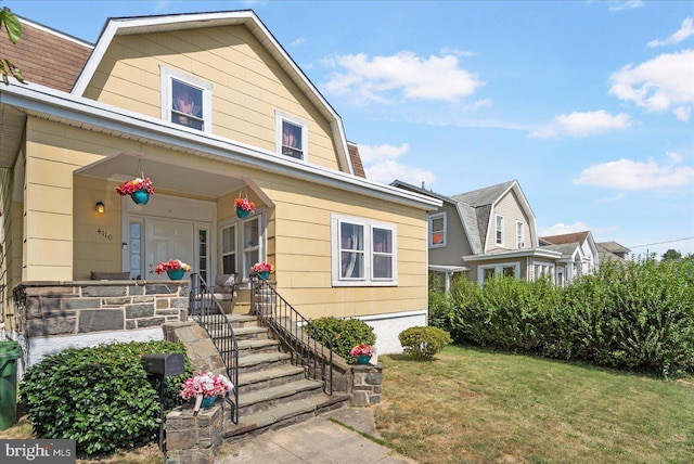 view of front facade featuring covered porch and a front yard