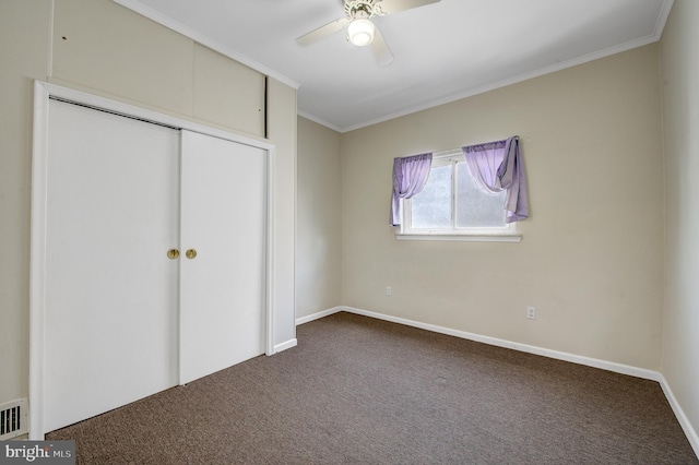 unfurnished bedroom featuring a closet, dark colored carpet, ceiling fan, and ornamental molding